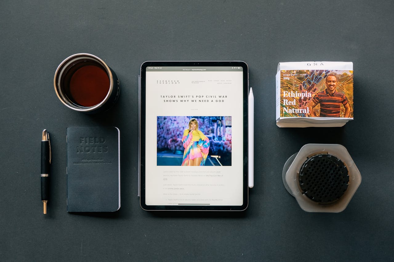 About Flat lay of a tablet, coffee, and notebook on a desk, ideal for productivity themes.