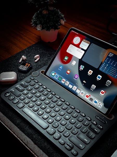 A Cozy Workspace Featuring An Ipad With A Keyboard Airpods And Elegant Lighting. 13791390 450x600