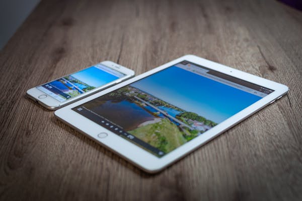 Ipad And Iphone Showing A Scenic Landscape On A Wooden Table Highlighting Portability And Technology. 10535365 600x400